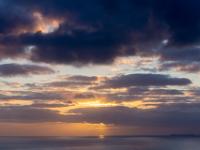 Wolkenfelder ziehen an aufgehender Sonne vorbei